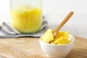 A little bowl with ghee, glass jar full of ghee on the kithcen table